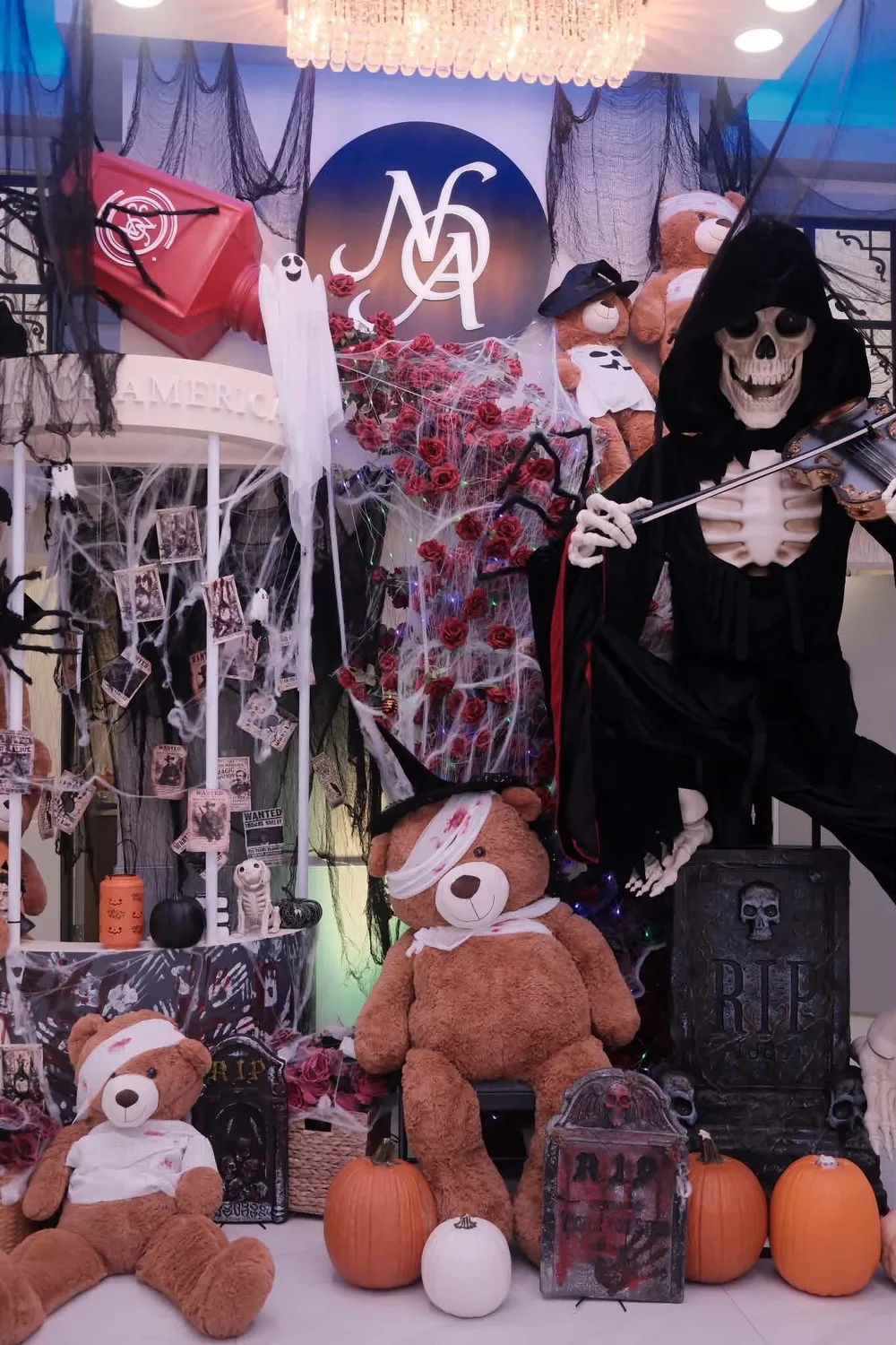 Halloween display with a skeleton violinist and costumed teddy bears