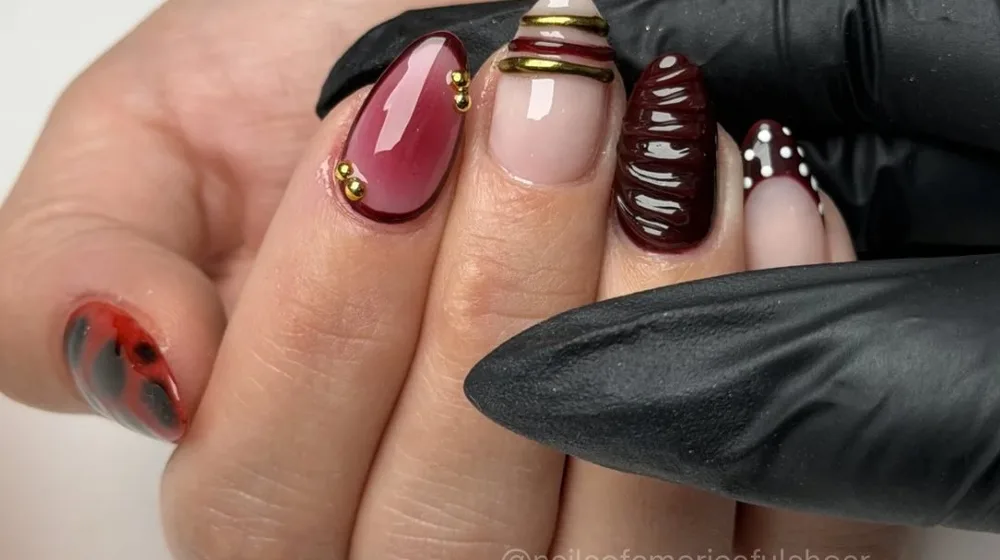 Wine and mauve nails with 3D swirl detail, finished by a technician