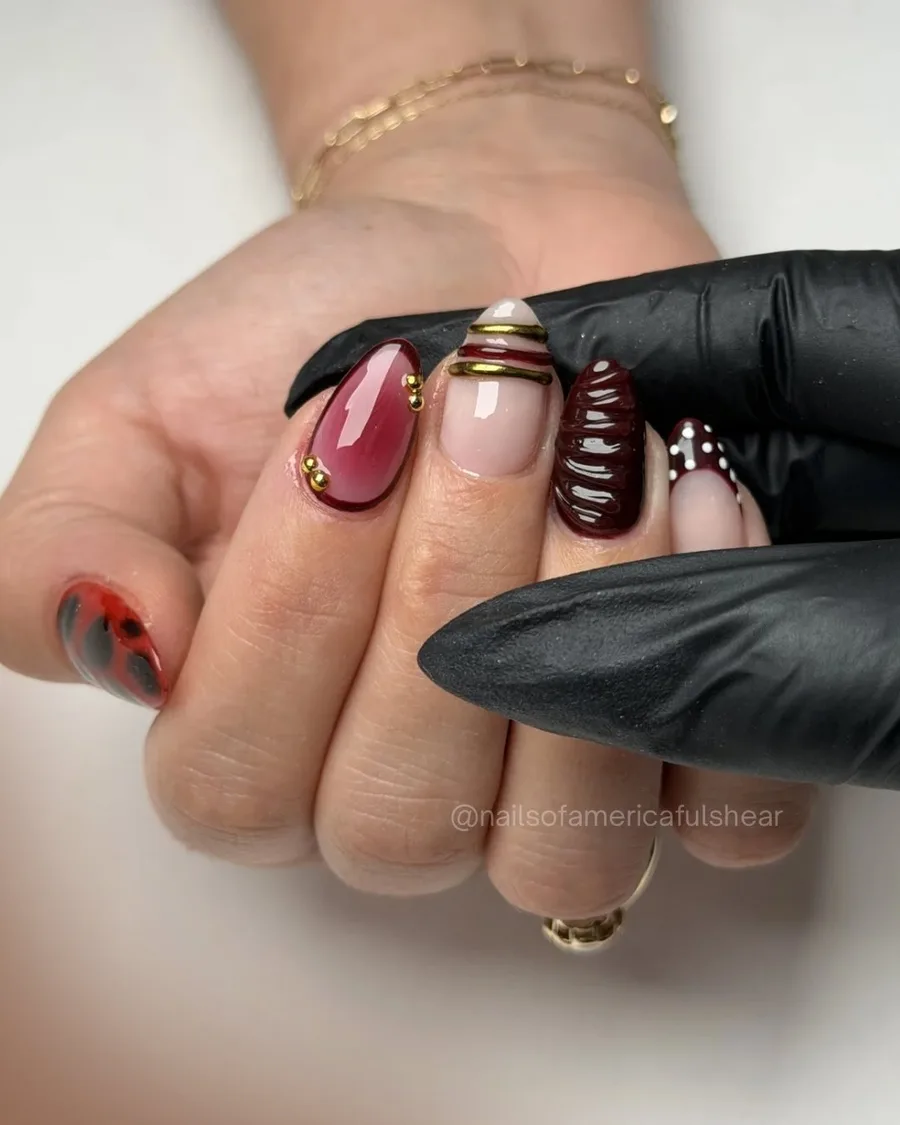 Wine-toned French swirl nails with sculpted 3D detail